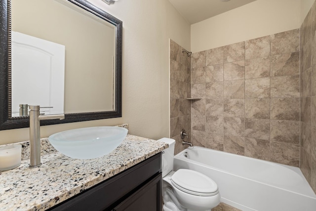 full bathroom featuring vanity, tiled shower / bath combo, and toilet