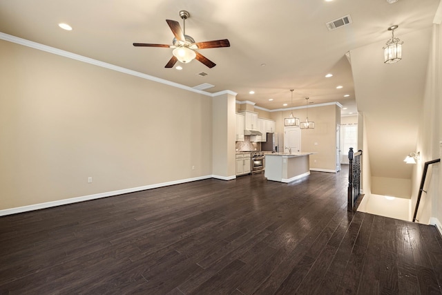 unfurnished living room featuring dark hardwood / wood-style flooring, ornamental molding, and ceiling fan