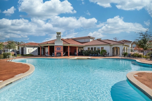 view of pool with a fireplace and a patio area