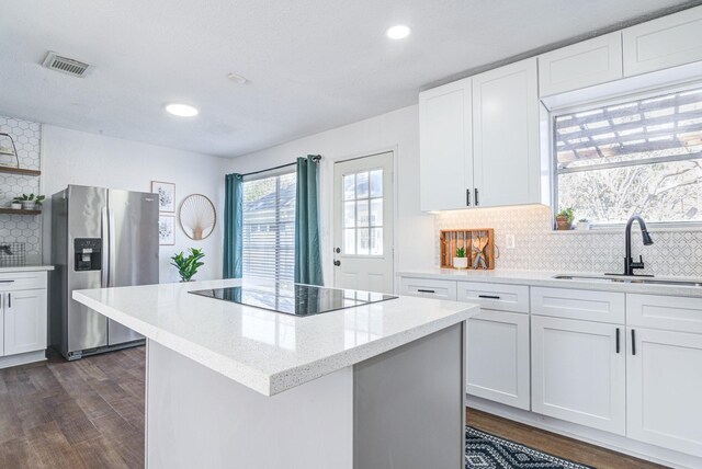 kitchen featuring white cabinetry, sink, and stainless steel fridge