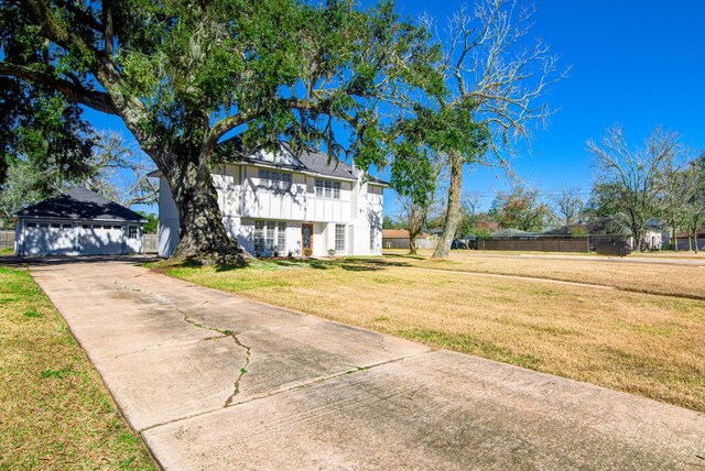 view of front of home with a front yard, fence, and an outdoor structure