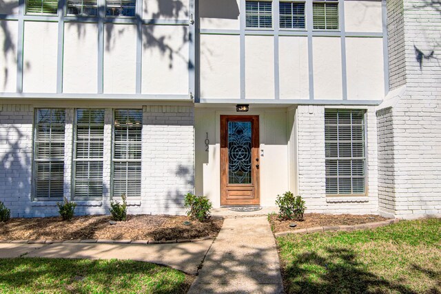 view of exterior entry featuring brick siding