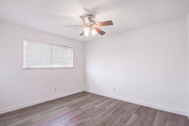 unfurnished room featuring ceiling fan, baseboards, and wood finished floors