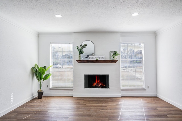 unfurnished living room with crown molding, dark hardwood / wood-style floors, and a textured ceiling