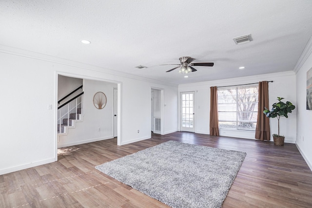 entryway with dark hardwood / wood-style flooring, ceiling fan, crown molding, and a textured ceiling