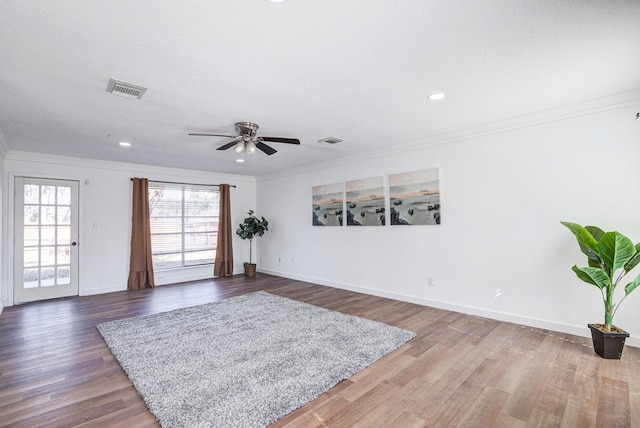 interior space with visible vents, crown molding, and wood finished floors