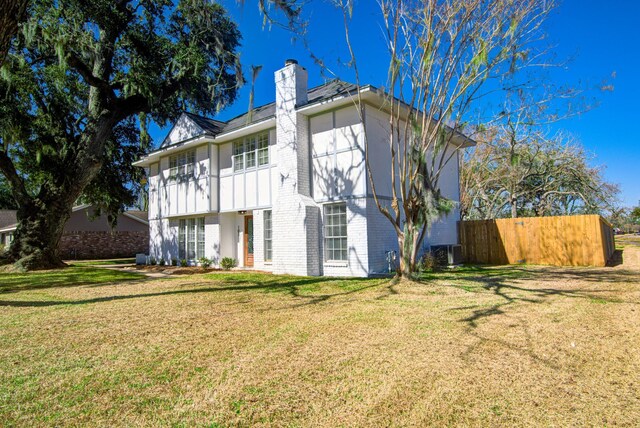 rear view of house featuring a yard and cooling unit