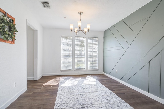 dining area featuring a textured ceiling, a notable chandelier, and dark hardwood / wood-style flooring