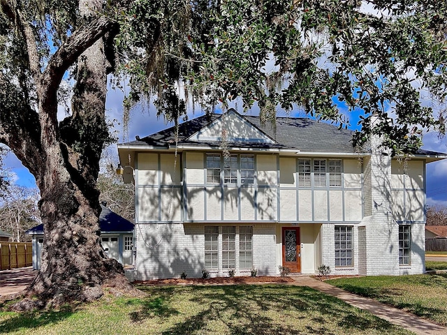 view of front of home featuring brick siding, a front lawn, and stucco siding