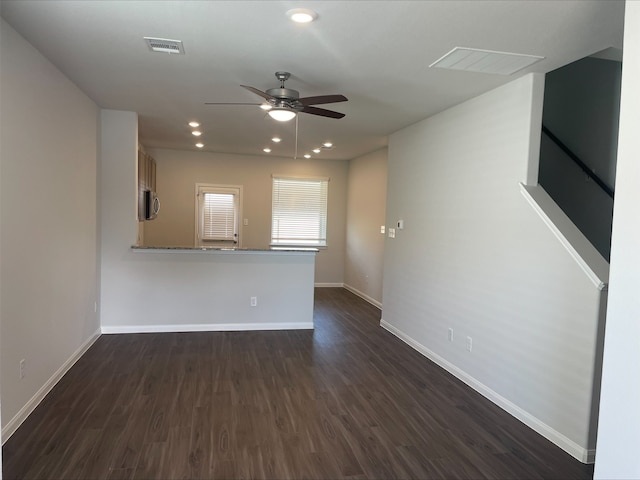 unfurnished living room with dark hardwood / wood-style floors and ceiling fan