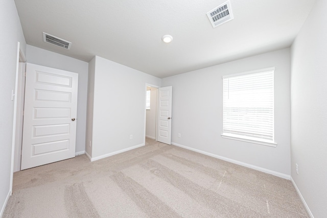 unfurnished bedroom featuring visible vents, carpet flooring, and baseboards