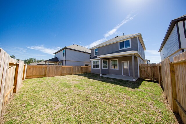 back of property featuring a fenced backyard, a patio, and a yard