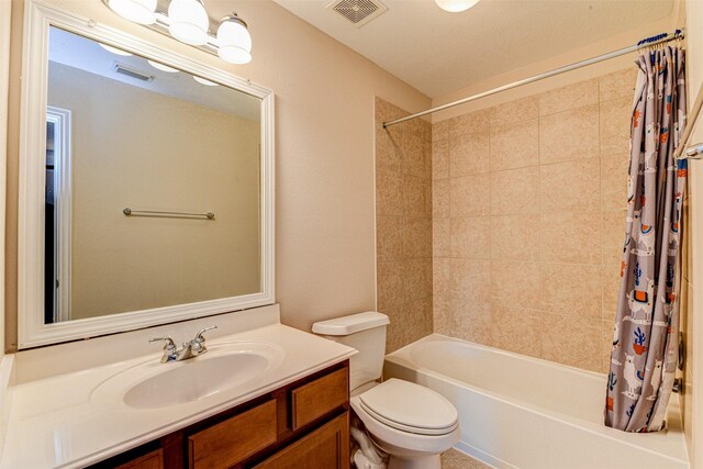 full bathroom with vanity, shower / tub combo, and toilet