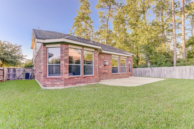 back of property with a patio area, central air condition unit, and a lawn