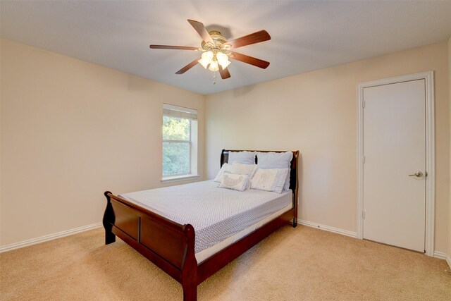 bedroom featuring light colored carpet and ceiling fan