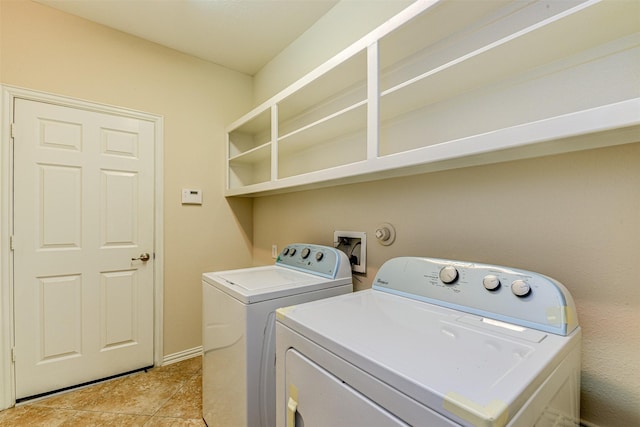 laundry area with washing machine and clothes dryer and light tile patterned flooring