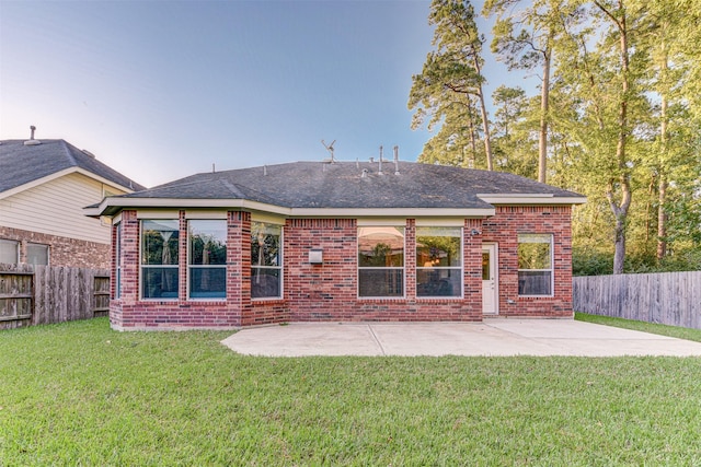 rear view of house featuring a lawn and a patio area