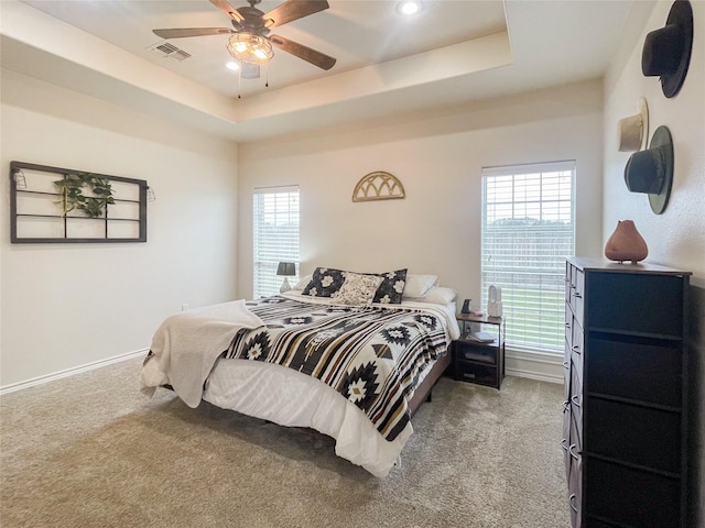 bedroom with carpet, ceiling fan, and a tray ceiling