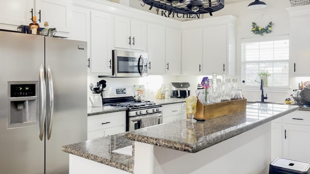 kitchen with a kitchen island, white cabinets, and appliances with stainless steel finishes