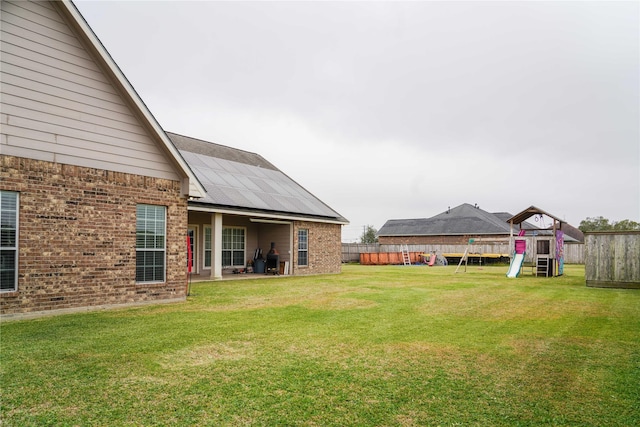 view of yard with a playground and a trampoline