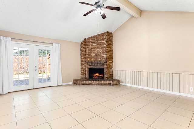 unfurnished living room featuring french doors, vaulted ceiling with beams, a brick fireplace, light tile patterned floors, and ceiling fan