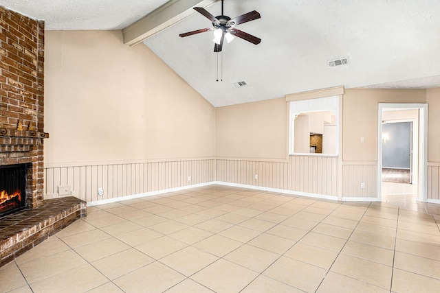 unfurnished living room featuring lofted ceiling with beams, a textured ceiling, light tile patterned floors, ceiling fan, and a fireplace