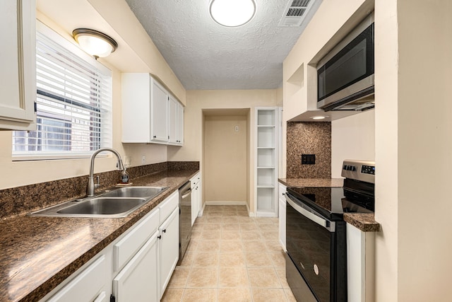 1727 Oakwell Ln, Katy, TX 77449 - kitchen featuring stainless steel appliances, a sink, dark countertops, a textured ceiling, and white cabinetry