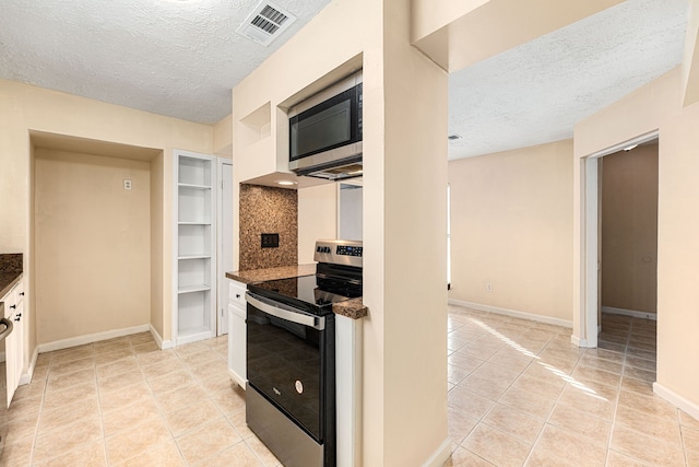 kitchen featuring light tile patterned flooring, appliances with stainless steel finishes, built in shelves, and a textured ceiling