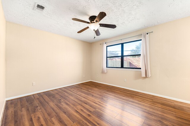 spare room with ceiling fan, dark hardwood / wood-style floors, and a textured ceiling