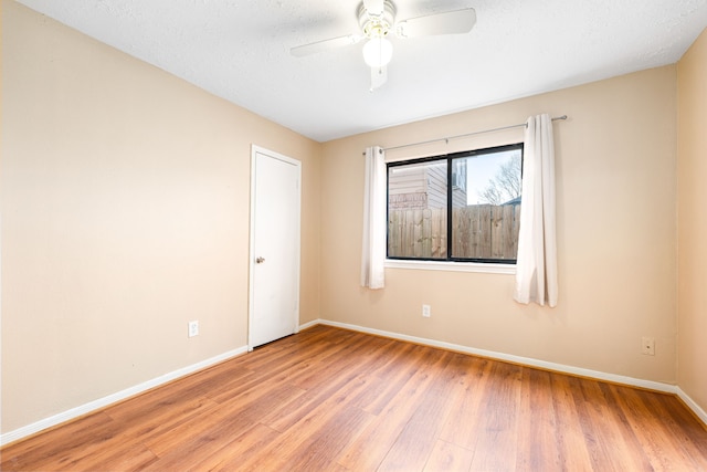 spare room featuring ceiling fan, a textured ceiling, and light wood-type flooring