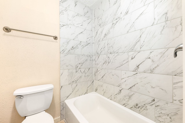 bathroom with toilet and tiled shower / bath combo