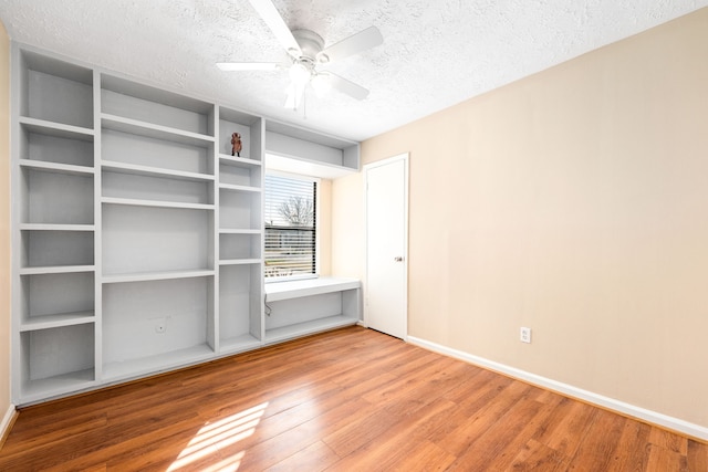 1727 Oakwell Ln, Katy, TX 77449 - unfurnished bedroom with wood finished floors, a textured ceiling, baseboards, and a ceiling fan