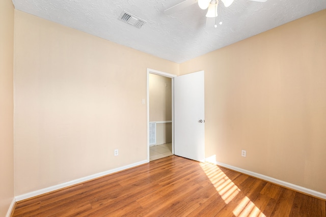 spare room with ceiling fan, hardwood / wood-style flooring, and a textured ceiling