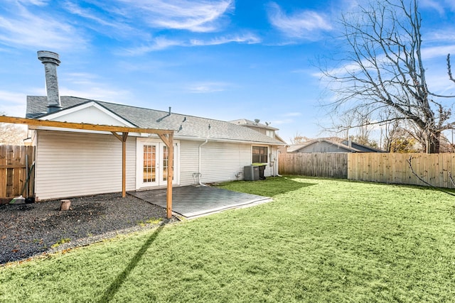 rear view of house with central AC, a patio, and a lawn