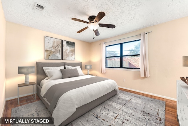 bedroom with ceiling fan, light hardwood / wood-style flooring, and a textured ceiling