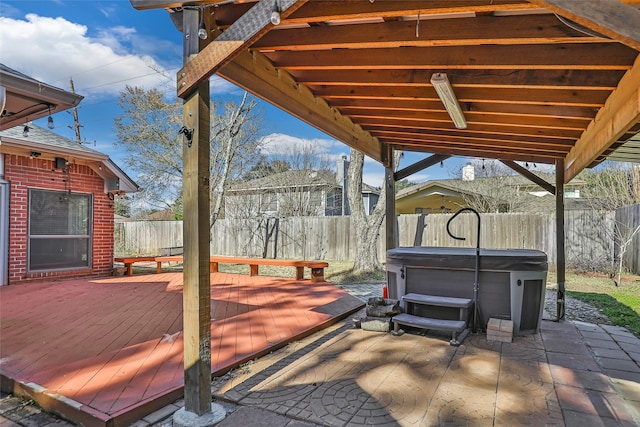 view of patio / terrace with a hot tub and a deck