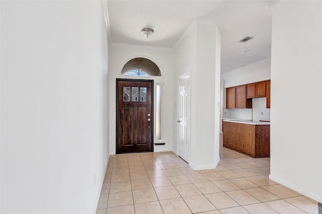 tiled foyer entrance with ornamental molding