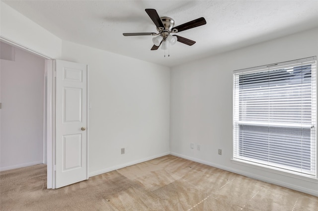 spare room with light colored carpet and ceiling fan