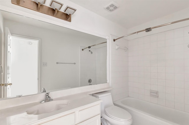 full bathroom with tiled shower / bath, vanity, and toilet