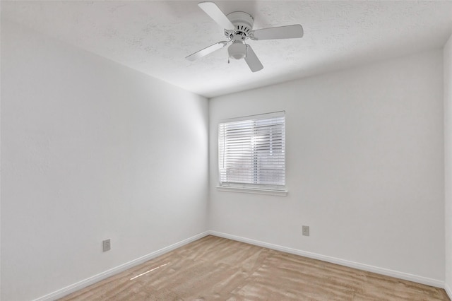 unfurnished room with ceiling fan and a textured ceiling