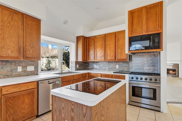 kitchen featuring tasteful backsplash, sink, black appliances, and a center island