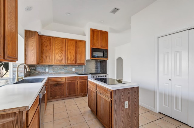 kitchen featuring dishwasher, a kitchen island, sink, and light tile patterned flooring