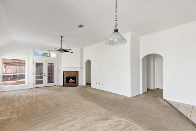 unfurnished living room featuring ceiling fan, ornamental molding, vaulted ceiling, and light carpet