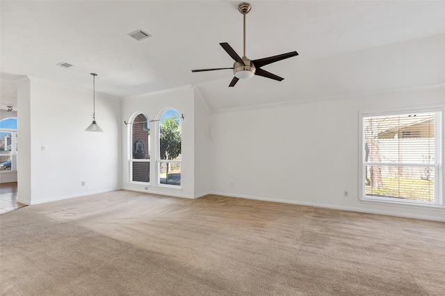 unfurnished living room with light carpet, crown molding, plenty of natural light, and ceiling fan