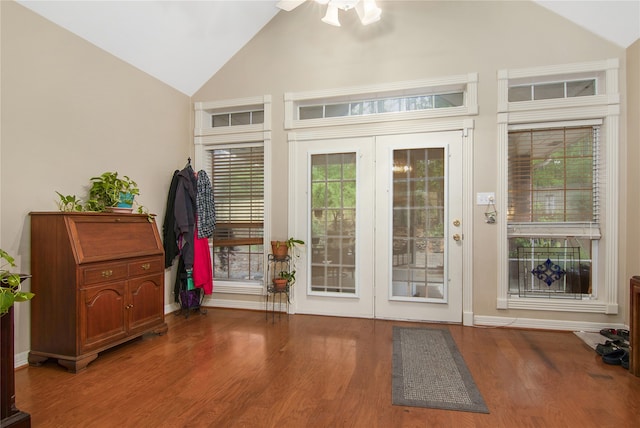 doorway with a ceiling fan, baseboards, high vaulted ceiling, and wood finished floors