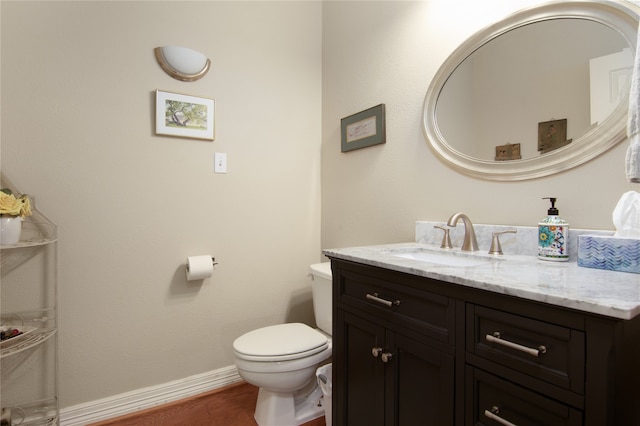 bathroom featuring vanity, wood-type flooring, and toilet