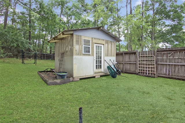 view of outdoor structure featuring a gate, a fenced backyard, and an outdoor structure