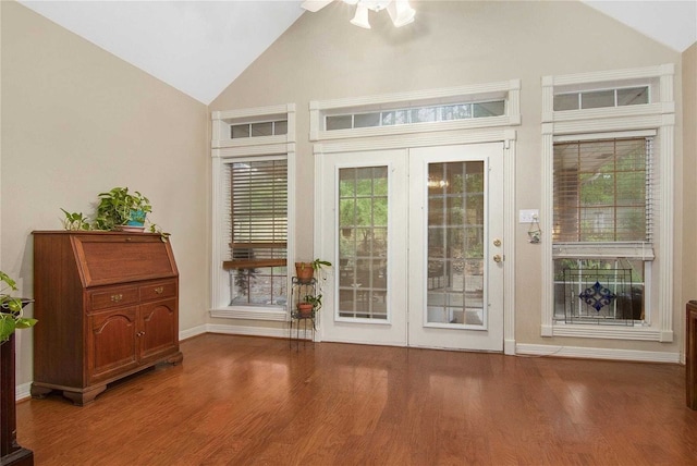 doorway featuring baseboards, high vaulted ceiling, ceiling fan, and wood finished floors