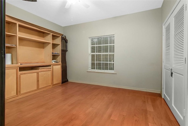 unfurnished bedroom with a closet, baseboards, light wood-style flooring, and a ceiling fan