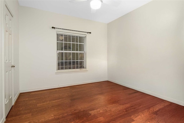 spare room featuring baseboards, ceiling fan, and wood finished floors